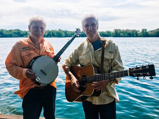 The duo Dusty Road in front of a lake.
