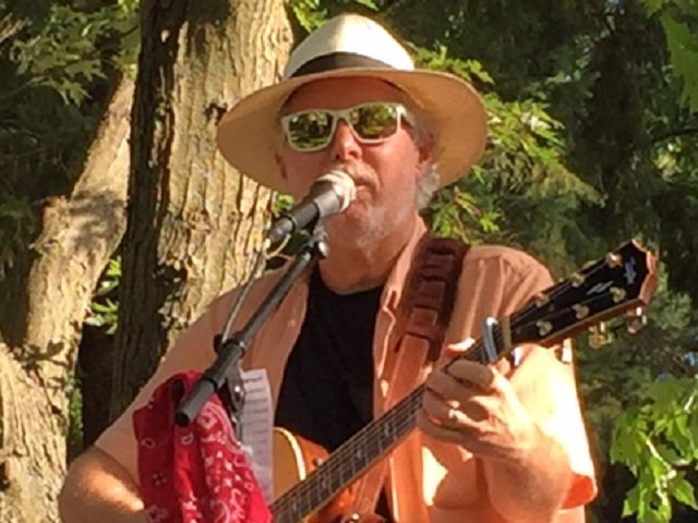A close-up of John Duggleby and guitar.